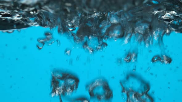 Boiling water close up on blue background.