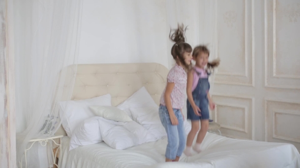 Two Little Girls Playing And Jumping On The Bed, Stock Footage | VideoHive