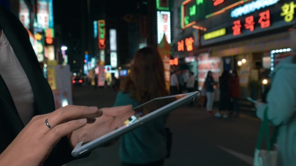 Woman Browsing In Web On Pad In Night Seoul, South Korea alt