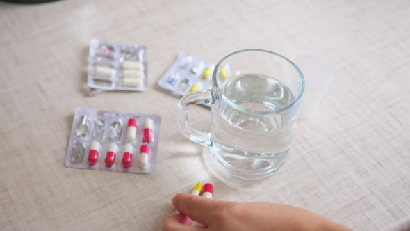 Woman Takes Medicine And Drinks Water
