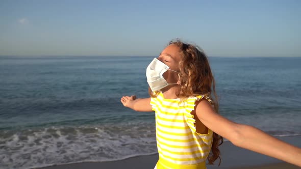 Happy child wearing medical mask outdoor against blue sky and sea