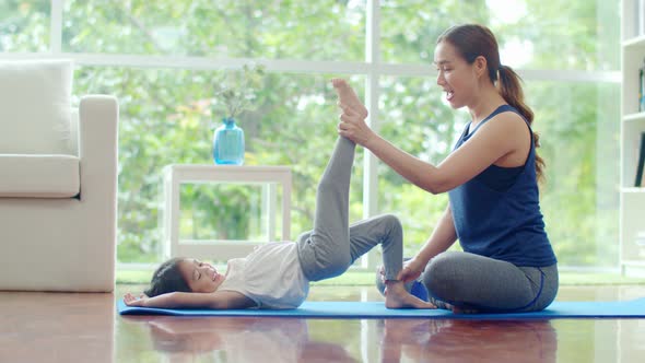 Young mother teaching her cute daughter for basic yoga