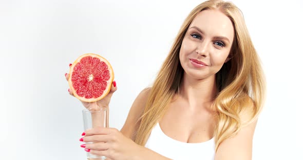 Woman Pressing Grapefruit Juice To Glass