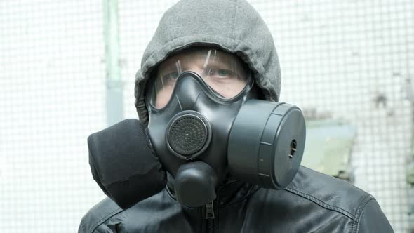 Man in Gas Mask at Epidemic Standing Outdoors alt