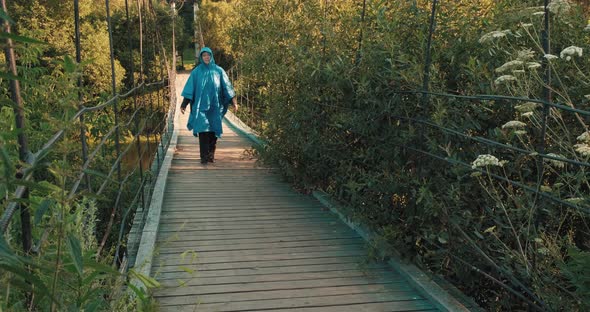 Woman in Blue Raincoat is Engaged in Hiking