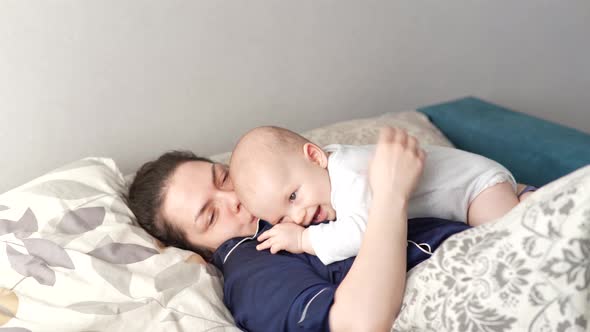 Mother Plays with Her Baby at Home on Her Lap