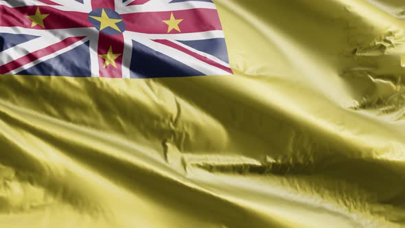 Niue textile flag waving on the wind. Slow motion. 20 seconds loop.  alt