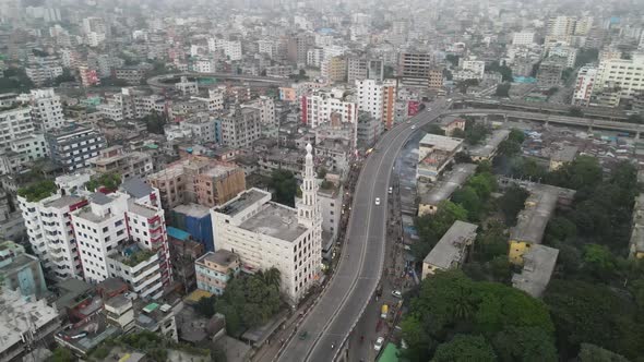 Mosque building with minaret beside highway in city. Aerial drone tracking circle shot alt