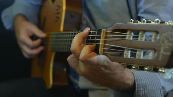 Hand of Male Musician Playing on Acoustic Guitar