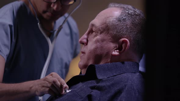 Doctor checking senior man's heart