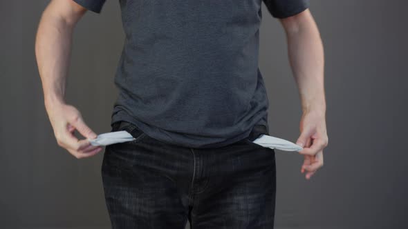 Penurious Man Twisting Empty Jeans Pockets. Poor Man Showing Empty Pockets. Poverty, Unemployment alt