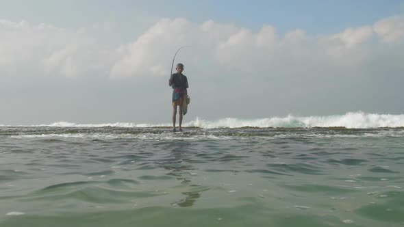 Aged Fisherman Silhouette Stands in Deep Blue Ocean Water alt