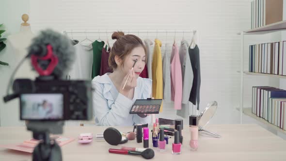 Beauty blogger present beauty cosmetics sitting in front camera for recording video alt