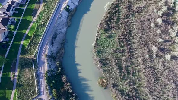 panning up from a straight down shot to reveal a suburb in a valley with mountains in the distance alt