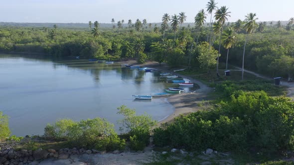Wooden boats on beach at Soco river mouth, Dominican Republic. Aerial circling alt