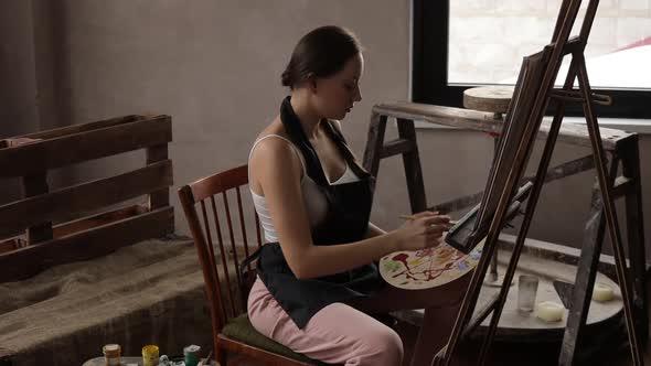 Calm Woman Painting in Light Home Studio