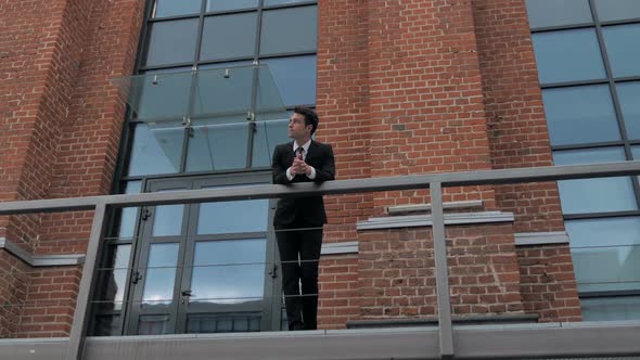 Businessman in Suit Standing Outside Loft Office alt