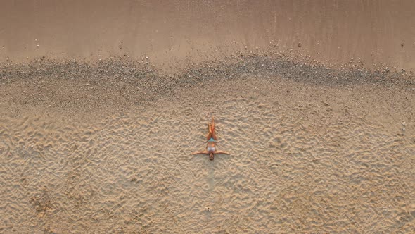Top Down View of Female Tourist at Sandy Beach and Turquoise Sea Waves Rolling at Shore Edge