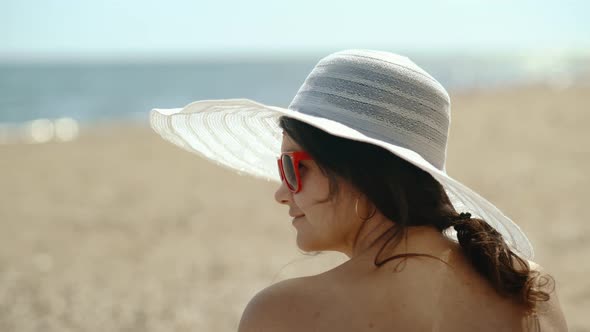 Portrait of a Young Girl in a Hat Who is Relaxing on the Sunny Coast alt