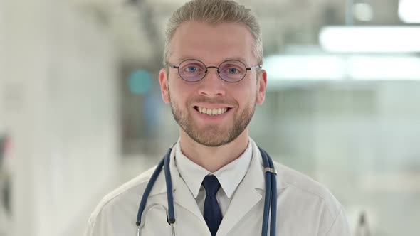 Portrait of Cheerful Young Male Doctor Smiling at the Camera alt