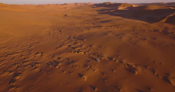 Cars Driving in Desert Between Sand Dunes