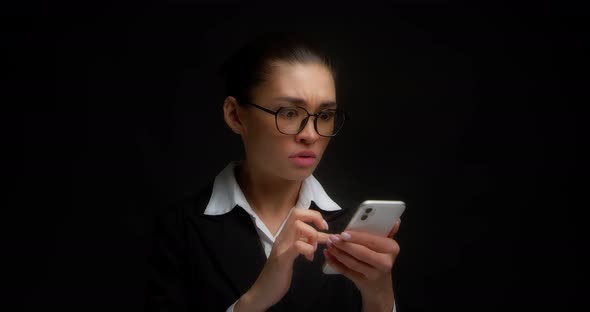 Business Woman Reads a Message on Her Smartphone with Horror