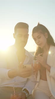Smiling Ethnic Couple Taking Self Portrait on Smartphone in Sunshine alt