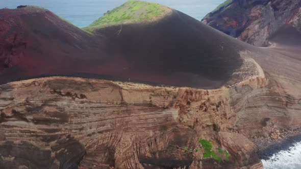 Man Walking on Cliff at Capelinhos Volcano Faial Island Azores Portugal alt