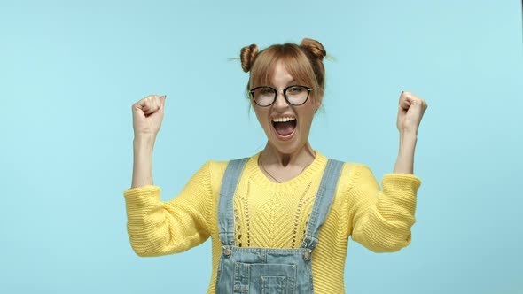 Cheerful Hipster Girl Winning and Rejoicing Scream Yes with Joy and Raising Hands for Fist Pumps