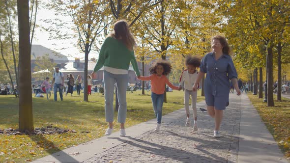 Happy Homosexual Family with Two African Daughters Playing Together in Park alt