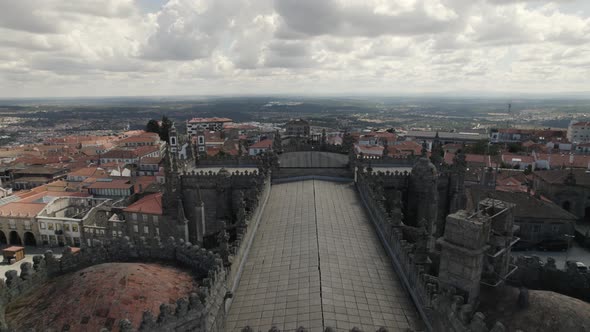 Flyover ornamented rooftop of Guarda City Historic Cathedral, Dramatic Cloudy Sky