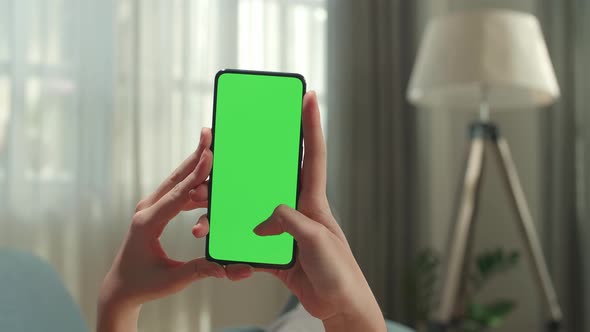 Close Up Of Hand Woman Lying On Couch Using Smartphone With Mock Up Green Screen Display alt