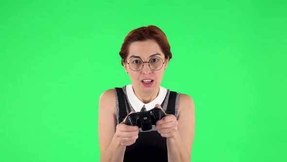 Portrait of Funny Girl in Glasses Is Playing Video Game Using Wireless Controller and Losing. Green alt