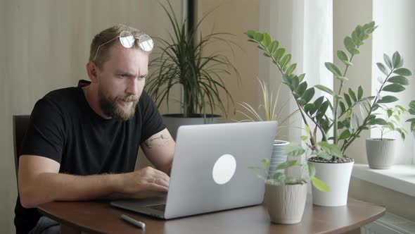 Man with a Beard Uses a Computer