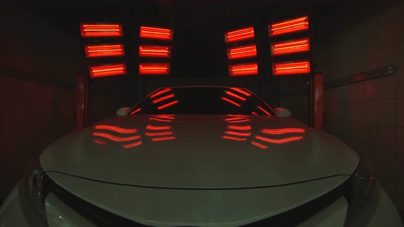 Red Lamps for Drying the Ceramic Coating Are Behind Car alt