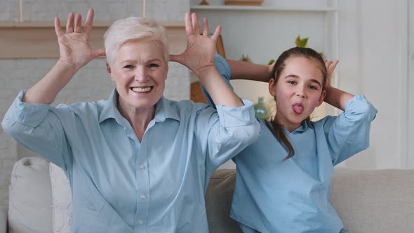 Cheerful Happy Two Age Generations Family Make Funny Faces Laugh Look at Camera Sitting on Sofa alt