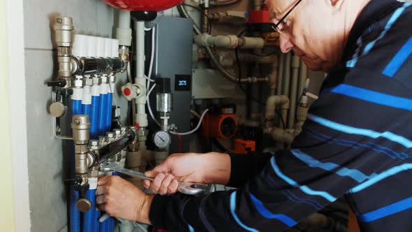 Professional plumber. Plumbing repair service. Repairman fixing a gas water heat alt