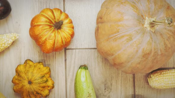 Autumn vegetables on wooden background. Pumpkins and corn, top view. alt