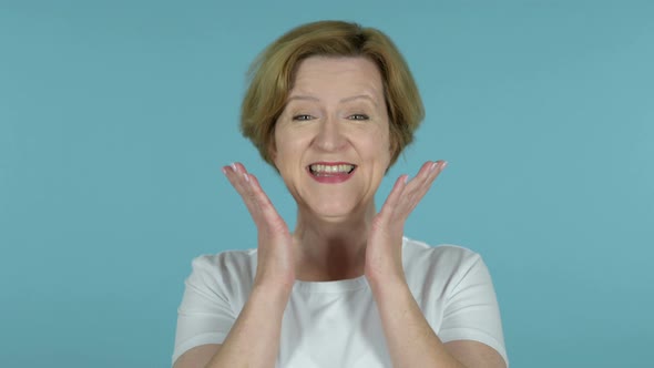 Happy Amazed Old Woman Surprised By Gift Isolated on Blue Background alt