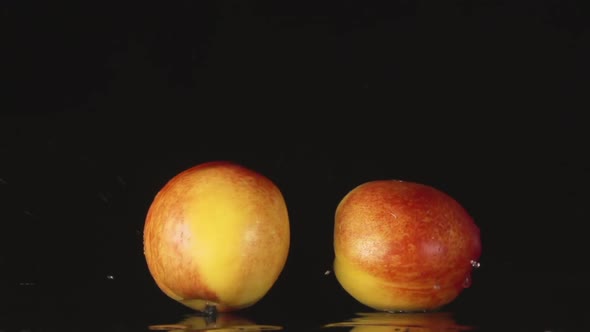 Two Nectarines Falls On A Black Background