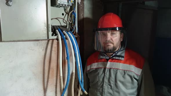 Electrician wearing hard hat and face shield to protect eyes and face. alt