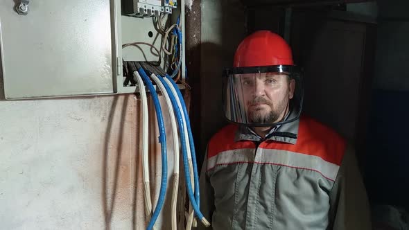 Electrician wearing hard hat and face shield to protect eyes and face.