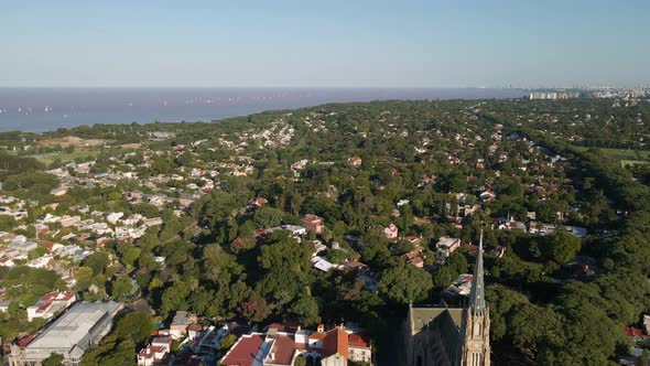 Aerial parallax shot of residential neighborhood in San Isidro and Buenos Aires city on background alt