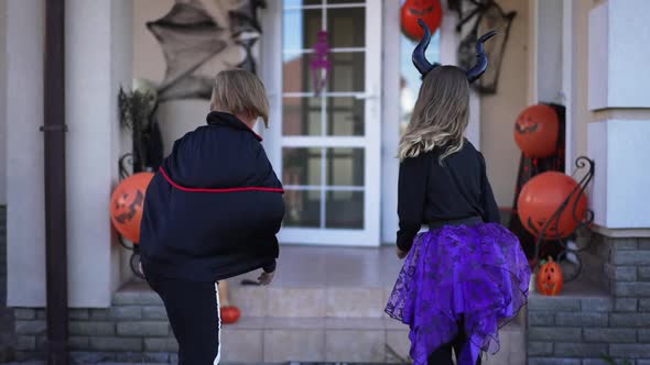 Live Camera Follows Cheerful Boy and Girl in Halloween Costumes Running Entering Decorated House on alt