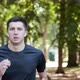 Adult Man Running Outdoor Using Wireless Earphones Listening to Music With Smartwatch - VideoHive Item for Sale