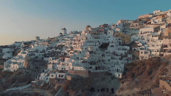 Aerial view flying over city of Oia on Santorini, Greece during the sunset