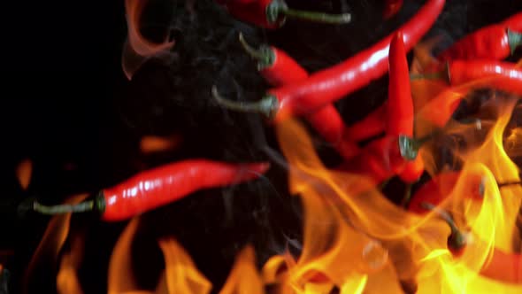 Super Slow Motion Shot of Falling Red Chilli Peppers to Fire at 1000Fps alt