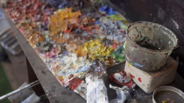 Close-up tilt-up shot reveals tools and workspace in an artist's workshop alt
