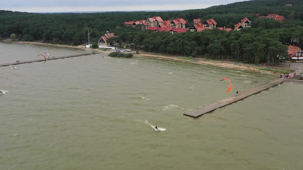AERIAL: Group of Surfers Uses Power Kites to Slide on the Surface of the Water alt