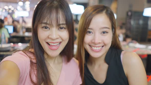 Point of view Asian young girls making a online video call on smartphone with their friend in store. alt